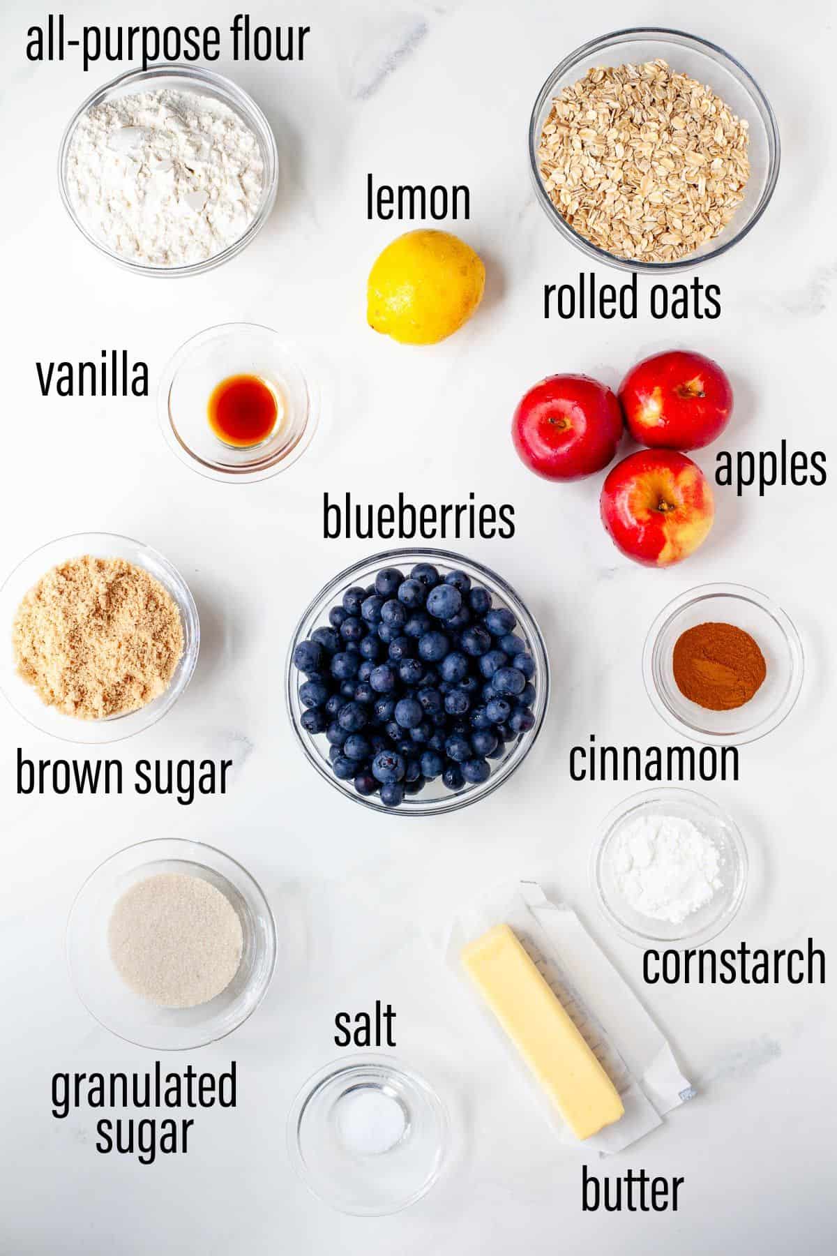 Graphic of ingredients for blueberry apple crisp on marble surface with black text overlay.